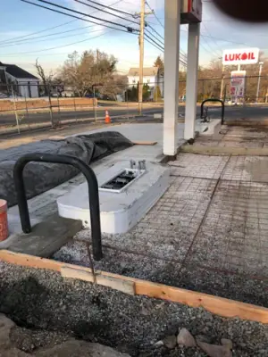 Reinforced concrete bay beside protective rails and equipment bases.