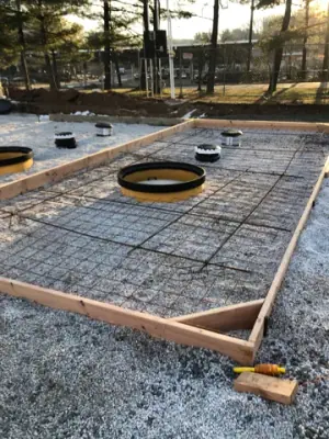 Reinforced concrete pad surrounding tank access openings.