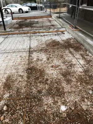 Reinforcing mesh spanning a formed concrete bay.