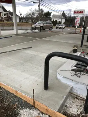 Finished concrete around a protective rail and equipment base.
