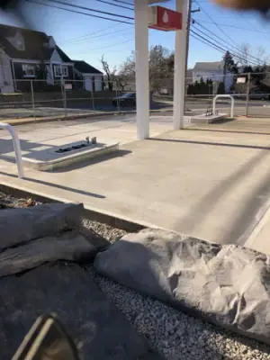 Concrete fueling lanes and protective rails beside the canopy.