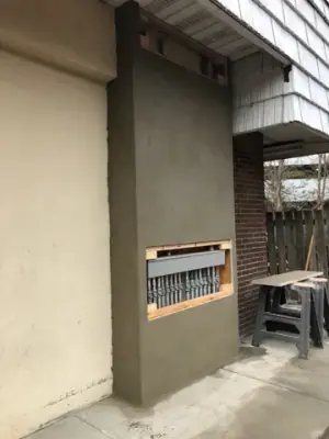 Building exterior wall and recessed opening above the walkway.