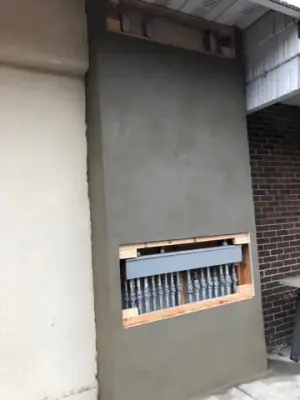Building exterior wall and recessed opening above the walkway.
