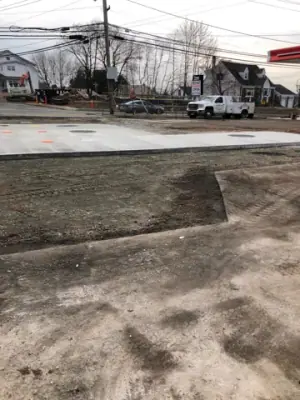 Graded aggregate and concrete tank pad across the forecourt.
