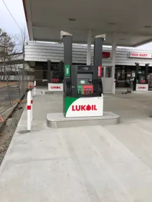 Installed Lukoil dispenser on the concrete fueling island.