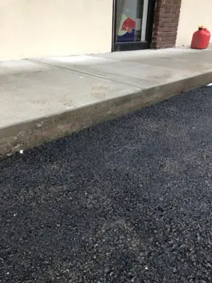 Close view of the asphalt-to-concrete walkway transition.