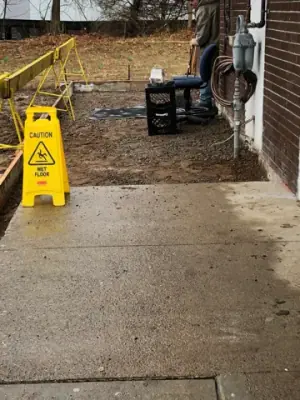Prepared ground and warning signs beside the building walkway.