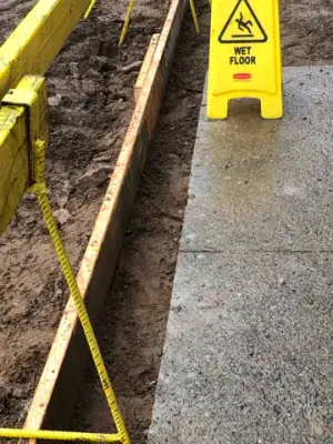 Narrow excavated strip along the existing walkway.