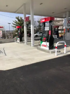 Installed dispensers and protective rails on the concrete fueling apron.