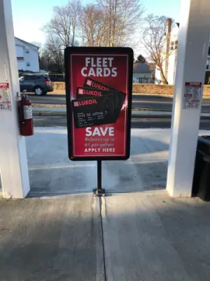 Promotional sign positioned between canopy columns on the finished concrete.