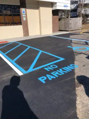 Blue striped accessible access aisle beside the building.