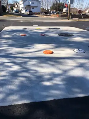 Concrete tank-access pad with multiple access covers.