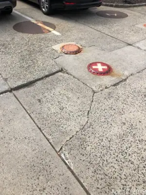Existing pavement with round marked tank access covers.